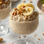 A mason jar of banana peanut butter oatmeal topped with fresh berries and granola