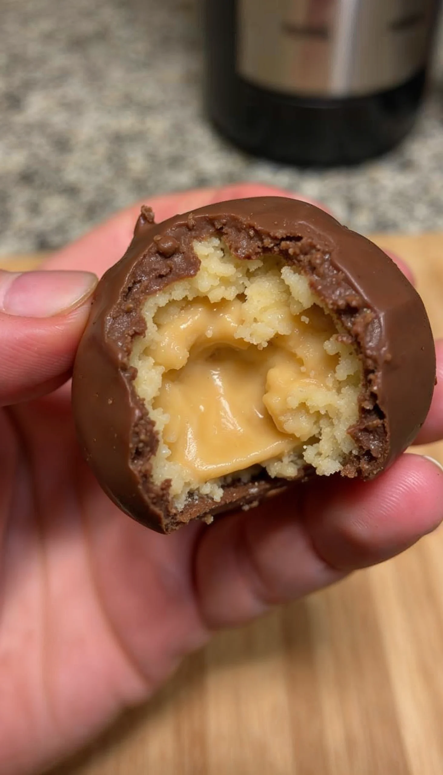 Close-up of a Butterfinger Ball with a bite taken out, showing the soft, peanut buttery center.