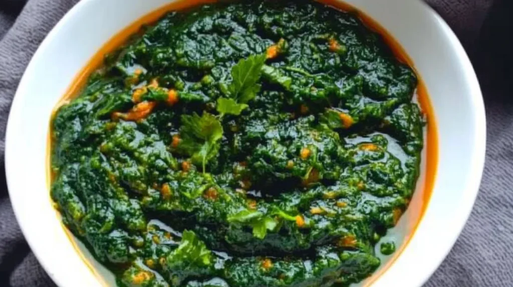 Freshly harvested pumpkin leaves on a rustic wooden table, showcasing their vibrant green color and healthy texture.