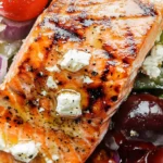 Mouth-watering grilled salmon salad with fresh greens, tomatoes, and a tangy dressing.