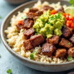 Grilled chipotle steak with char marks, garnished with lime and cilantro.